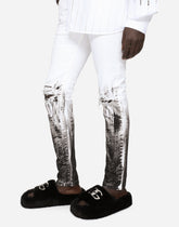 Skinny stretch jeans with rips and brushstrokes - | Dolce & Gabbana