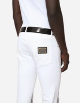 Skinny stretch jeans with rips and brushstrokes - | Dolce & Gabbana