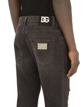 Loose black wash jeans with rips and DG patch -  | Dolce &amp; Gabbana
